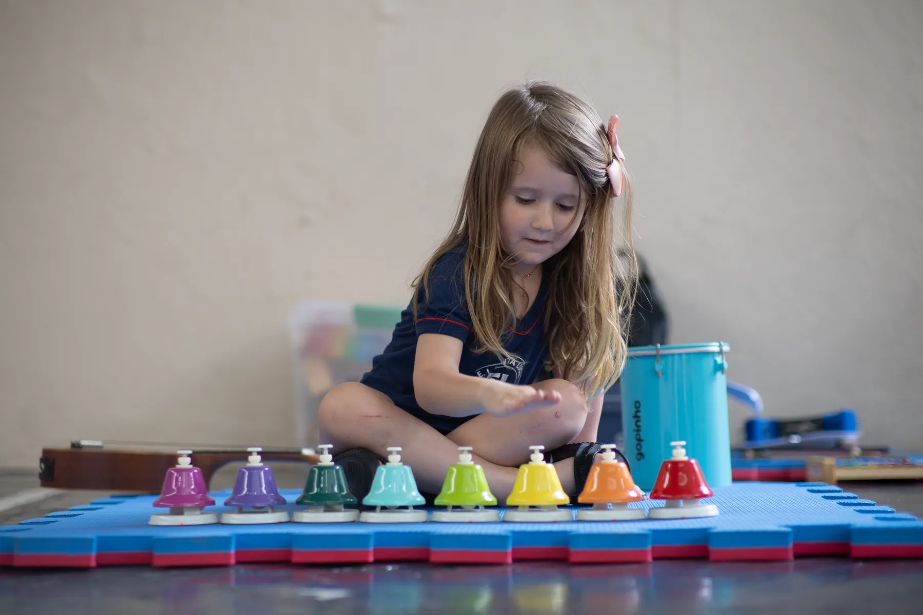 Aluna experimentando instrumentos de musicalização